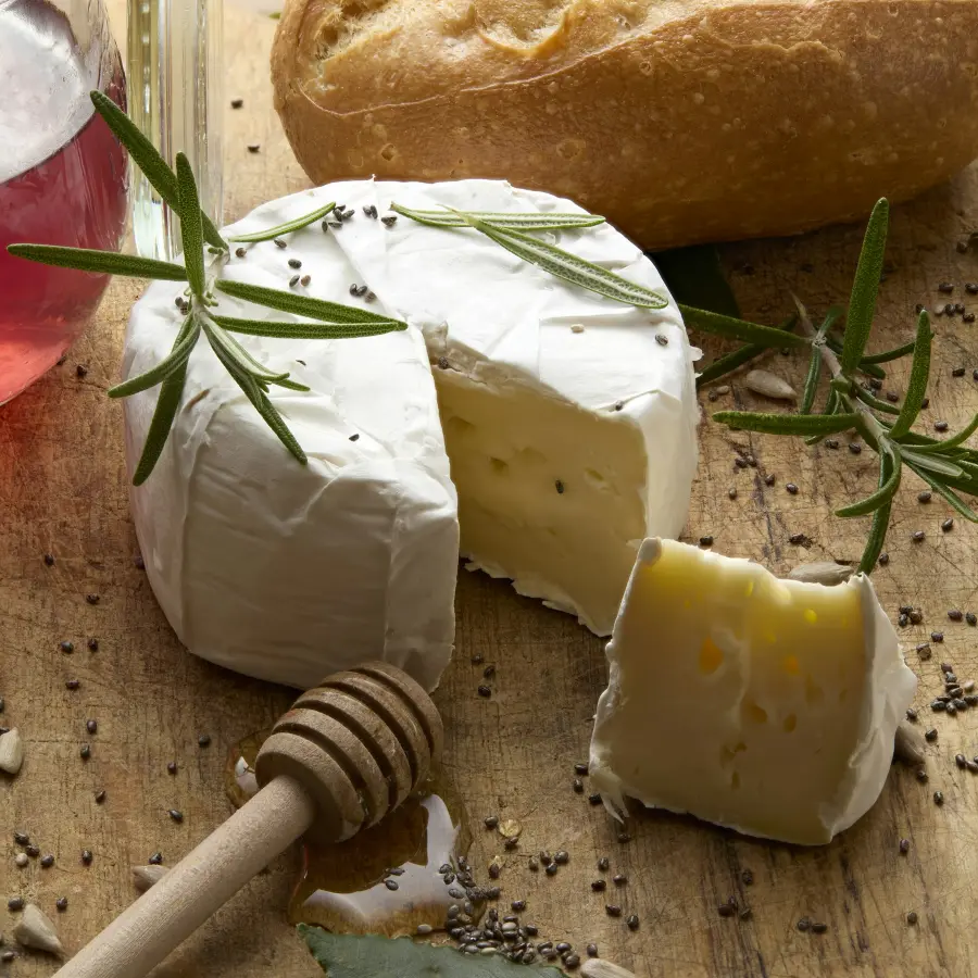 Brie met brood en honing op een houten plank